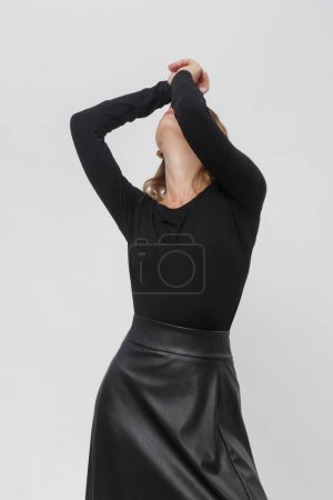 Serie of studio photos of female model in all black look, sh