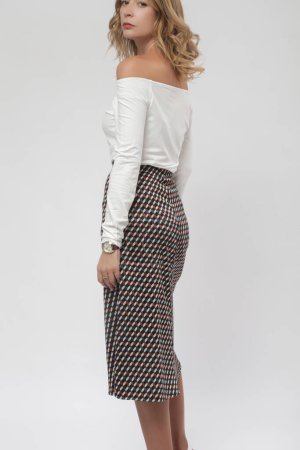 Serie of studio photos of female model wearing viscose fitted white shirt and patterned midi skirt with slit