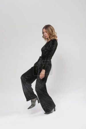 Serie of studio photos of female model in black plush jumpsuit