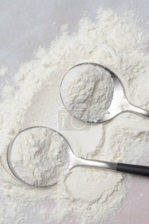 White powder in the spoon. Collagen protein powder or wheat flour. Concept of nutritional supplement, dieting, detox, preventive healthcare and healthy lifestyle.