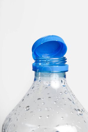 Gros plan du nouveau bouchon fixé à la bouteille en plastique, relié au col de la bouteille par une languette solide fixée à l'anneau de sécurité. Elles visent à encourager le recyclage, dans le cadre de la lutte contre les déchets.