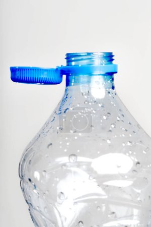 Nahaufnahme des neuen Verschlusses, der an der Plastikflasche befestigt ist und mit dem Flaschenhals durch eine stabile Lasche verbunden ist, die am Sicherheitsring befestigt ist. Sie sollen das Recycling als Teil des Kampfes gegen Abfall fördern.