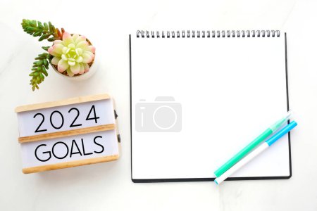 2024 objetivos en caja de madera y fondo de papel cuaderno en blanco, plantilla de año nuevo 2024 negocio