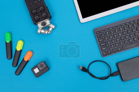 Photo for Top View of Photographers, Videographers or Video Bloggers Workplace. Digital Gadgets Lying on Blue Table - Flat Lay - Royalty Free Image