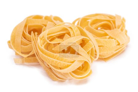 Drei klassische italienische Roh-Ei-Fettuccine - isoliert auf weißem Hintergrund. Dry Twisted Uncooked Pasta. Italienische Kultur und Küche. Raw Golden Macaroni Pattern - Isolation
