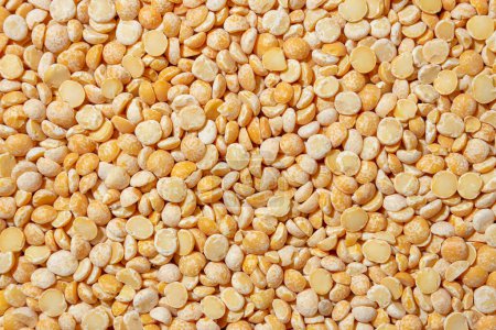 Photo for Uncooked Polished Split Peas Background. A Culinary Canvas of Dry Yellow Peas, Creating a Lively and Textured Background for Gourmet Cooking. Scattered Raw Polished Peas. Healthy Eating Ingredients - Royalty Free Image