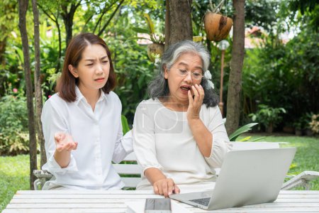 Téléchargez les photos : Asiatique fille enseignement vieille femme âgée utiliser en ligne Les médias sociaux dans l'ordinateur portable après la retraite. Concept de technologie de l'apprentissage et adaptation des personnes âgées - en image libre de droit