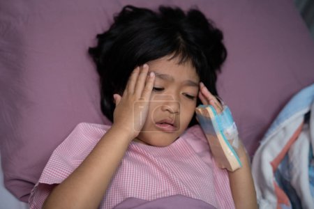 Foto de Una niña asiática tiene una máscara de oxígeno y respira a través de un nebulizador en el hospital. Concepto de bronquitis, tratamiento respiratorio y médico, inhalación de medicamentos, niebla, de un nebulizador. - Imagen libre de derechos