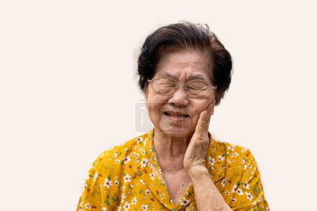 Asia alte Seniorin leidet unter starken Zahnschmerzen, hält ihre Wange und leidet unter starken Zahnschmerzen auf weißem Hintergrund, Karies, Zahnempfindlichkeit, Mundgesundheit Konzept.