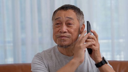 Les hommes âgés aveugles asiatiques utilisent assistant numérique obtenir la facilité d'accès aux fonctions sur smartphone, la saisie vocale sur le téléphone. Handicapés visuels et maladies oculaires chez les personnes âgées Concept, Téléphone accessible.