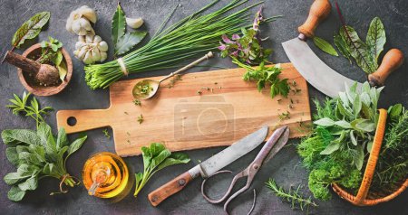 Foto de Varias hierbas frescas del jardín con utensilios de cocina en la mesa rústica. Vista superior con espacio de copia - Imagen libre de derechos