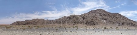 Foto de Paisaje con una gama de colinas de sedimentos conglomerados cerca del cañón de Serisem, filmado con luz brillante a finales de primavera en el desierto de Naukluft, Namibia, África - Imagen libre de derechos