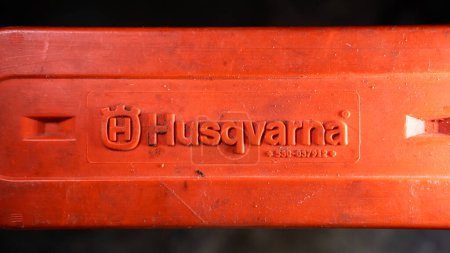 Photo for Kyiv, Ukraine - August 17, 2022: Protective tire cover of an old orange chainsaw with the logo of the Husqvarna company close-up - Royalty Free Image