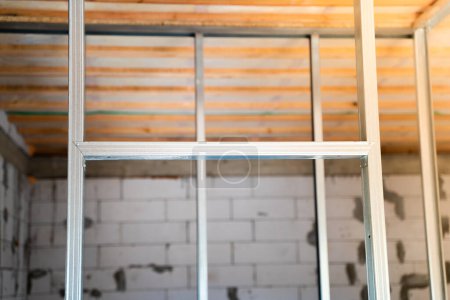 Photo for Constructed metal frame for drywall panels. Frame from a metal profile for the walls of the room. Bare walls of a freshly built private house without repair - Royalty Free Image