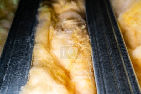 Photo for Glass wool between metal profiles in the wall. Universal insulation material for sound and heat insulation - Royalty Free Image