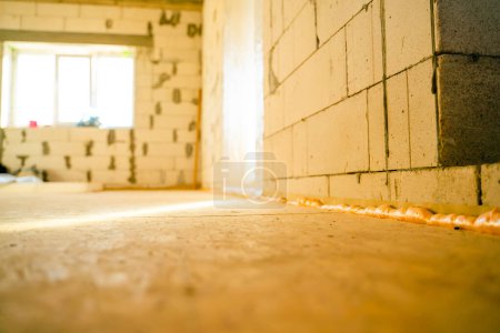 Photo for Light beam on an oriented strand board subfloor. The first leveling layer of OSB boards. Renovation process in a newly built private house. Thin long sun sunset beam at a construction site - Royalty Free Image