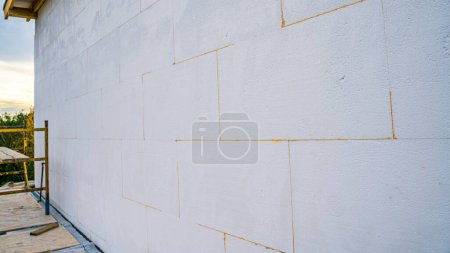 Téléchargez les photos : Mur de la maison isolé avec gros plan en mousse de polystyrène. Préparation d'une maison privée pour l'hiver - en image libre de droit
