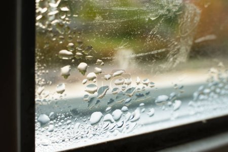Kondenswassertropfen auf dem Fenster in Nahaufnahme. Luftfeuchtigkeit und Temperaturunterschied zwischen Straße und Raum