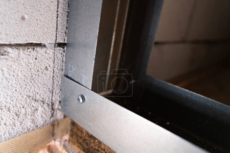 Photo for Two metal profiles are connected at a right angle with a stainless steel self-tapping screw with a drill close-up. Assembling the frame for drywall from a metal profile - Royalty Free Image