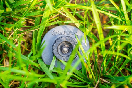 Téléchargez les photos : Kiev, Ukraine - 20 juin 2023 : Gardena S80 pop-up sprinkler, close-up. Système d'irrigation de gazon de qualité en été.Arrosage de gazon intégré dans le sol de la pelouse - en image libre de droit