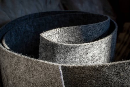 Foto de Densa delgada gris fieltro primer plano. Material textil grueso no tejido hecho de lana fieltrada en un rollo - Imagen libre de derechos