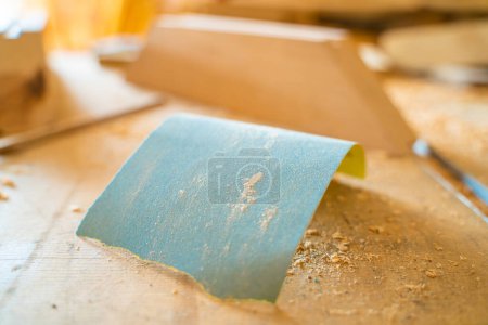 Foto de Un trozo de papel de lija azul sobre una mesa en un taller de carpintería - Imagen libre de derechos