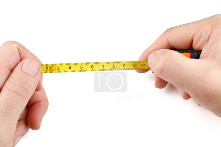 Self-retracting metal tape measure in hands. Man with measuring tape on white background