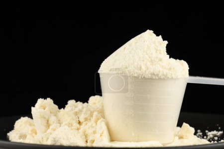 Scoop of protein powder on a black background.