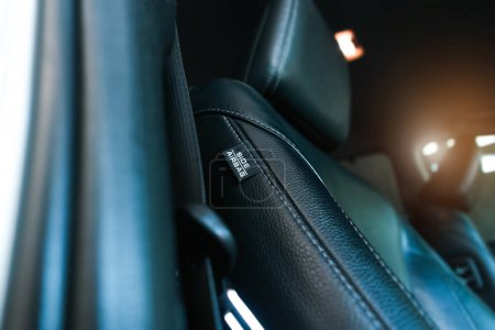Téléchargez les photos : Étiquette Airbag sur le côté du siège en cuir à l'intérieur de la voiture, système Airbag et concept de sécurité automobile - en image libre de droit