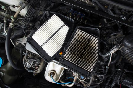 Téléchargez les photos : Comparison of new and old car air filters that are clogged up on the engine compartment, Automotive maintenance service concept - en image libre de droit