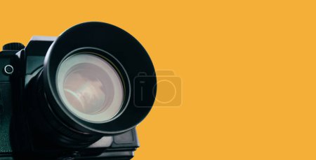 Photo for Front lens of vintage film camera with black body isolated on yellow background, banner with copy space, clipping path included. - Royalty Free Image