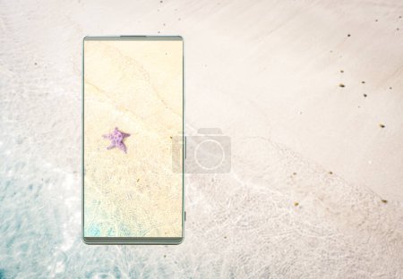 Photo for Clarity and vivid colors of the smartphone screen, Smartphone with the image of the starfish on the sand beach, right copy space for text, phone screen technology concept. - Royalty Free Image