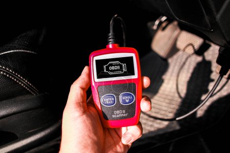 OBD scanner tool , OBD2 scanner in a car mechanic hand for car engine system analysis , Car maintenance and servicing concept