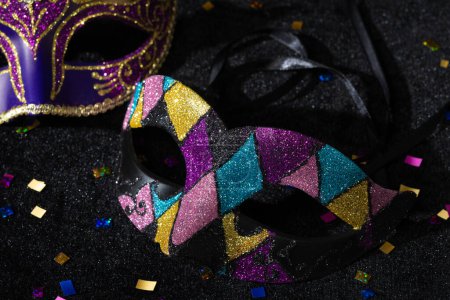 Photo for Close-up view of Masquerade mask with confetties on black background. - Royalty Free Image