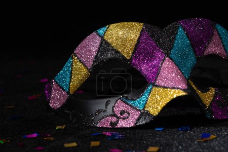 Photo for Masquerade mask with glitters and confetties on black background. - Royalty Free Image