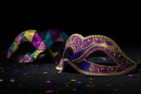Photo for Close-up view of Masquerade mask with confetties on black background. - Royalty Free Image