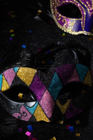 Photo for Close-up view of Masquerade gold mask with glitters and confetties on black background. - Royalty Free Image