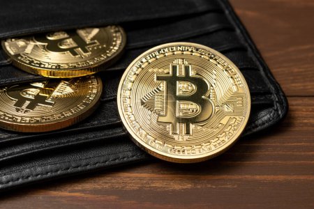 Photo for Close up view of Bitcoin gold coins in wallet on table. - Royalty Free Image