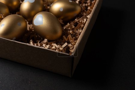 Photo for Gold eggs in paper box on black background. - Royalty Free Image
