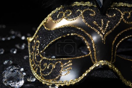 Photo for Close-up view of Masquerade gold mask with gemstones on black background. - Royalty Free Image