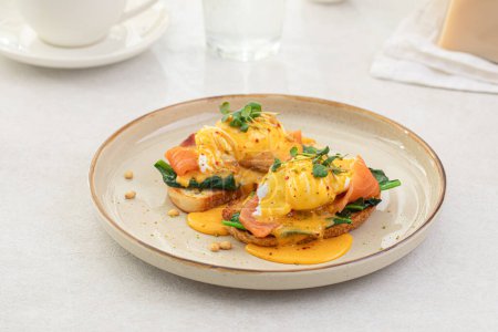 Foto de Porción de huevos tostada benedicta con salmón y hierbas desayuno - Imagen libre de derechos