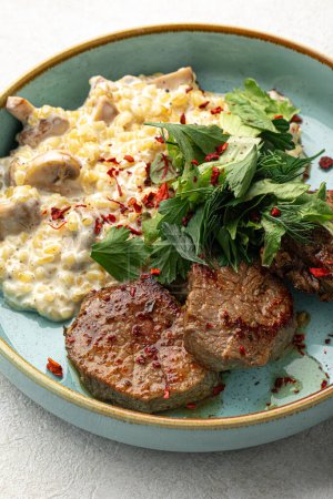 Photo for Portion of beef medallions and garnish with mushrooms - Royalty Free Image