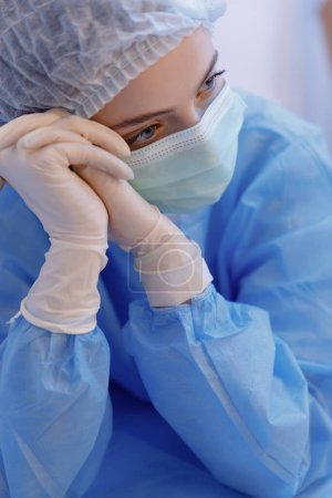 Téléchargez les photos : Une prise de vue rapprochée d'une infirmière portant des blouses pleines et regardant directement la caméra. - en image libre de droit