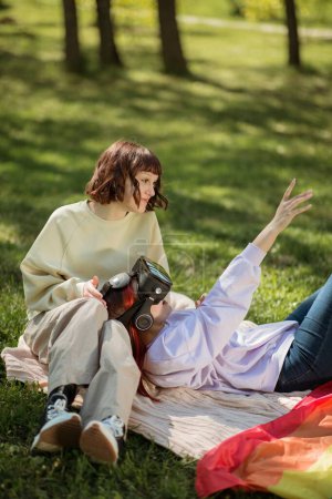 Photo for In the middle of nature in a sunny day lesbian couple have a great picnic time they using virtual reality glasses to have a fun time together. Lgbt - Royalty Free Image