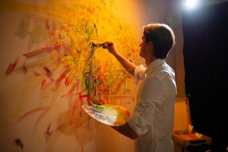 Téléchargez les photos : Dans le studio d'art artiste homme peinture nouvelle peinture contemporaine il utilise les doigts et ajouter un peu de couleur à l'huile sur l'image. Peinture - en image libre de droit