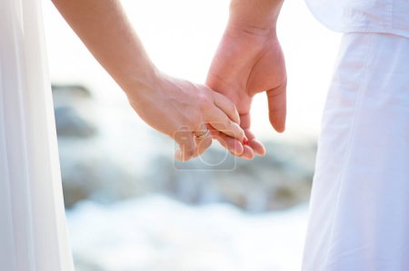 Téléchargez les photos : Amour - couple romantique tenant la main sur une plage au coucher du soleil. - en image libre de droit