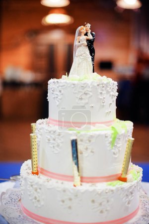 Téléchargez les photos : Gâteau de mariage blanc traditionnel avec sculptures de mariée et marié. - en image libre de droit