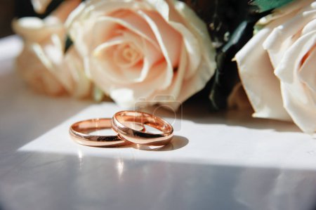 Téléchargez les photos : Couple d'alliances en or avec des fleurs - en image libre de droit