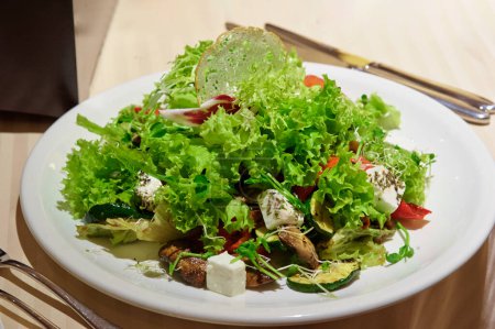 Foto de Ensalada con carne y verduras a la parrilla y queso fetta en la mesa del restaurante - Imagen libre de derechos