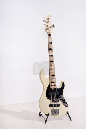 Photo for Bass rock guitar stands near white wall - Royalty Free Image